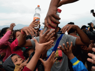 Displaced people in Nepal reach for water from an aid organization. Source: Agence France Presse (AFP)