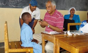 In Kenya, a deaf child is examined by a physician with the help of an interpreter. Source: Flickr user Community Eye Health